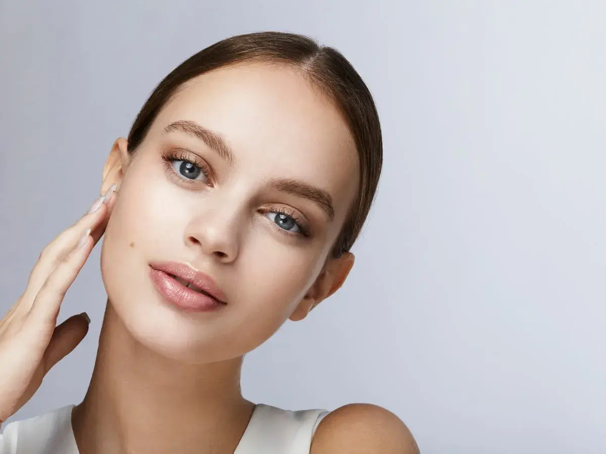 Joven con piel radiante y labios sutiles, ideal para aprender como maquillarse paso a paso.