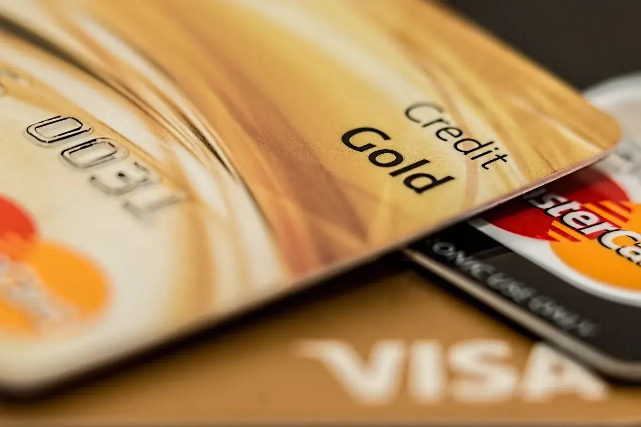 Cartes de crédit dorées, dont une "Gold", superposées. Pensez aux frais bancaires au Portugal pour ces paiements.
