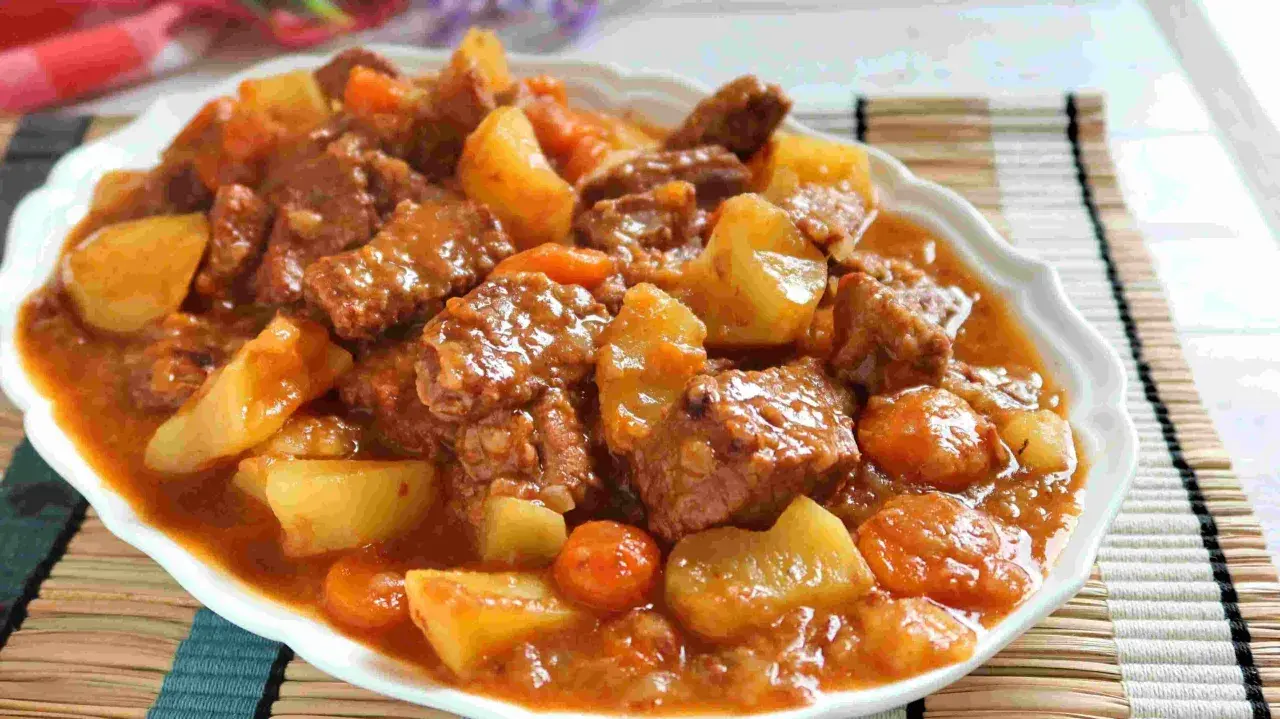 Un plato humeante de estofado de ternera con patatas y zanahorias en una salsa rica y sabrosa.