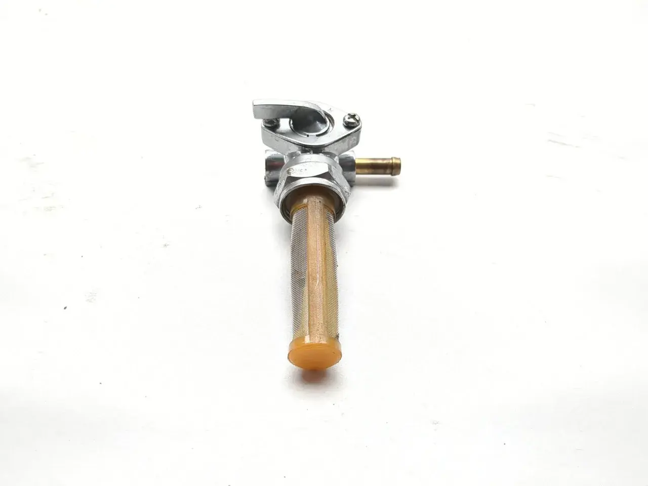 Llave de gasolina para moto con filtro. Permite controlar el flujo de combustible en sus posiciones llave.