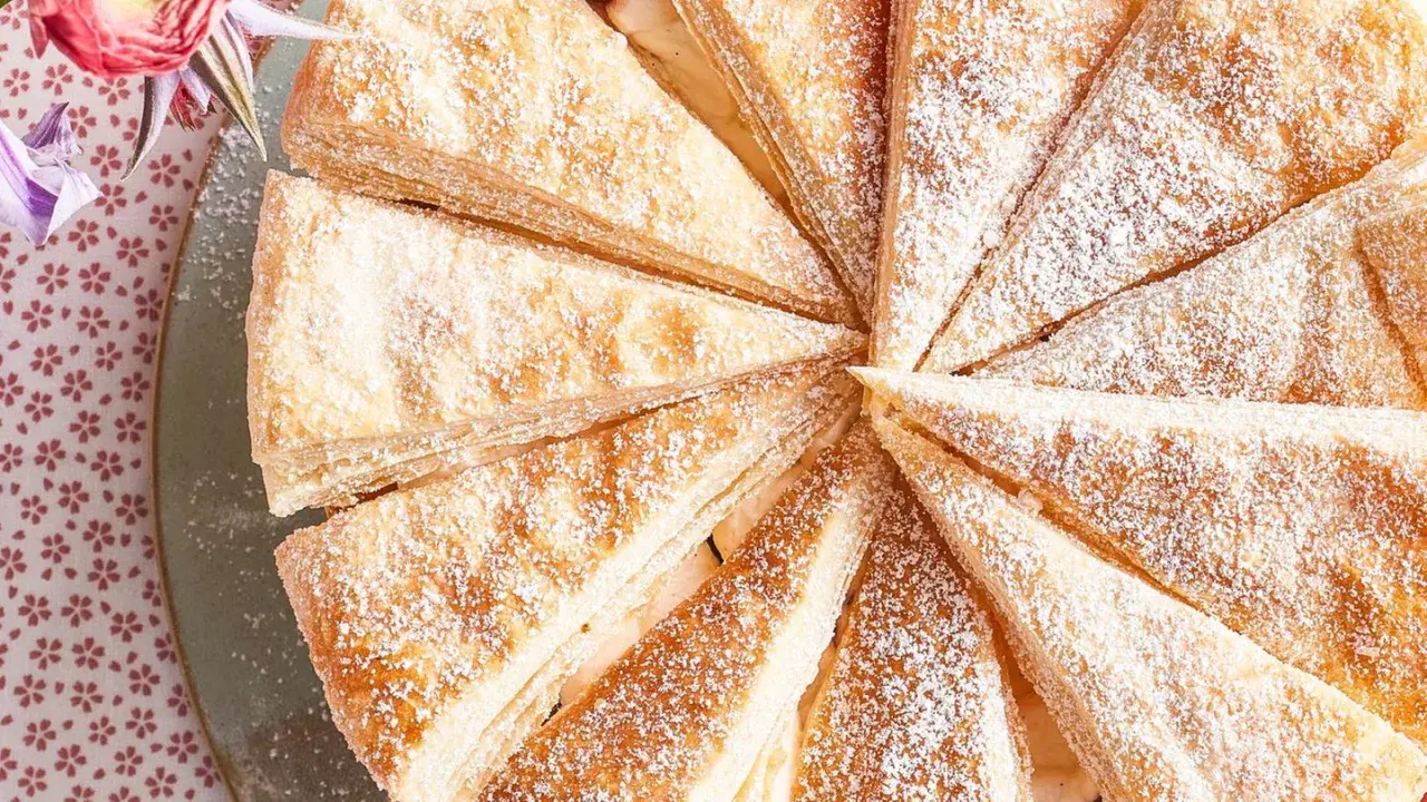 Ein Anschnitt einer köstlichen Friesentorte, bestäubt mit Puderzucker. Dieses Rezept ist ein Genuss!