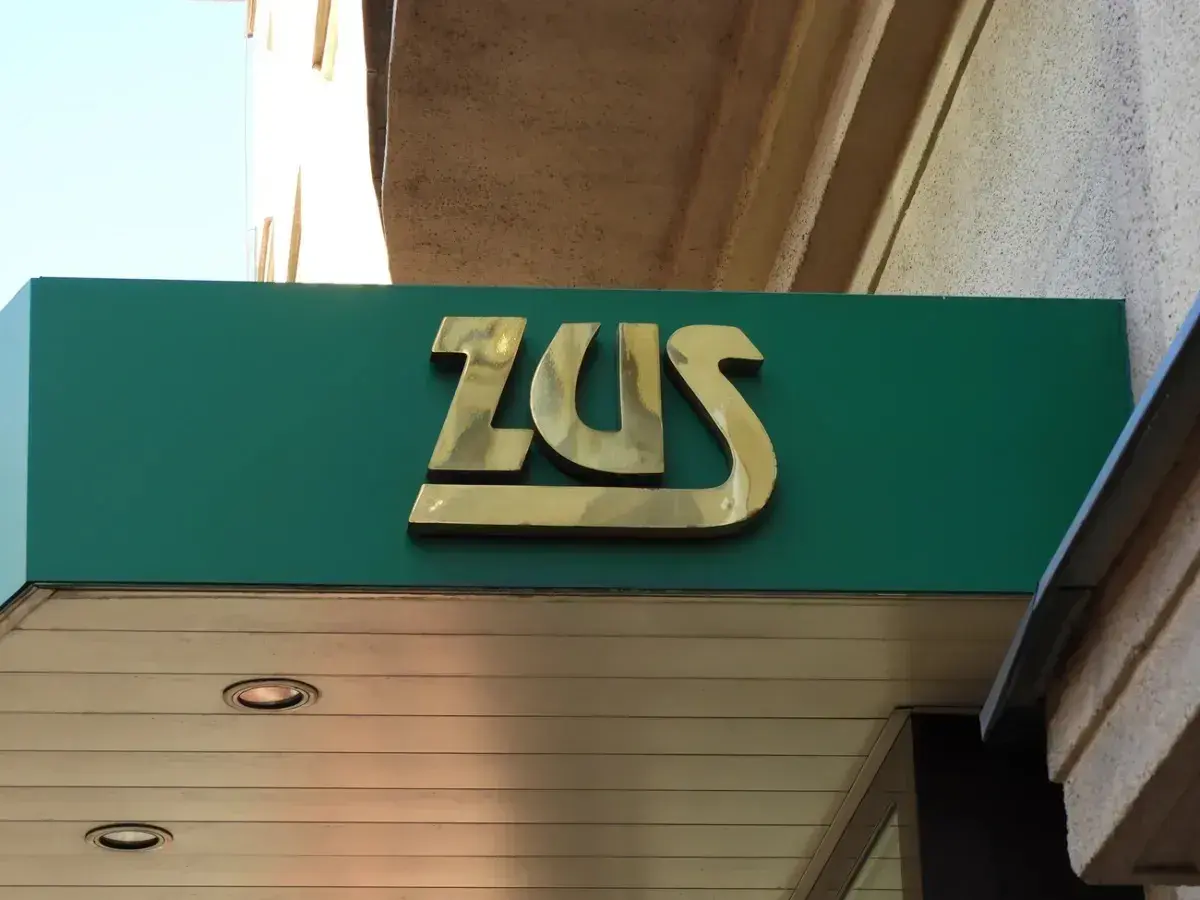 Złote logo ZUS na zielonym tle. Może to miejsce, gdzie załatwisz świadczenie urlopowe.