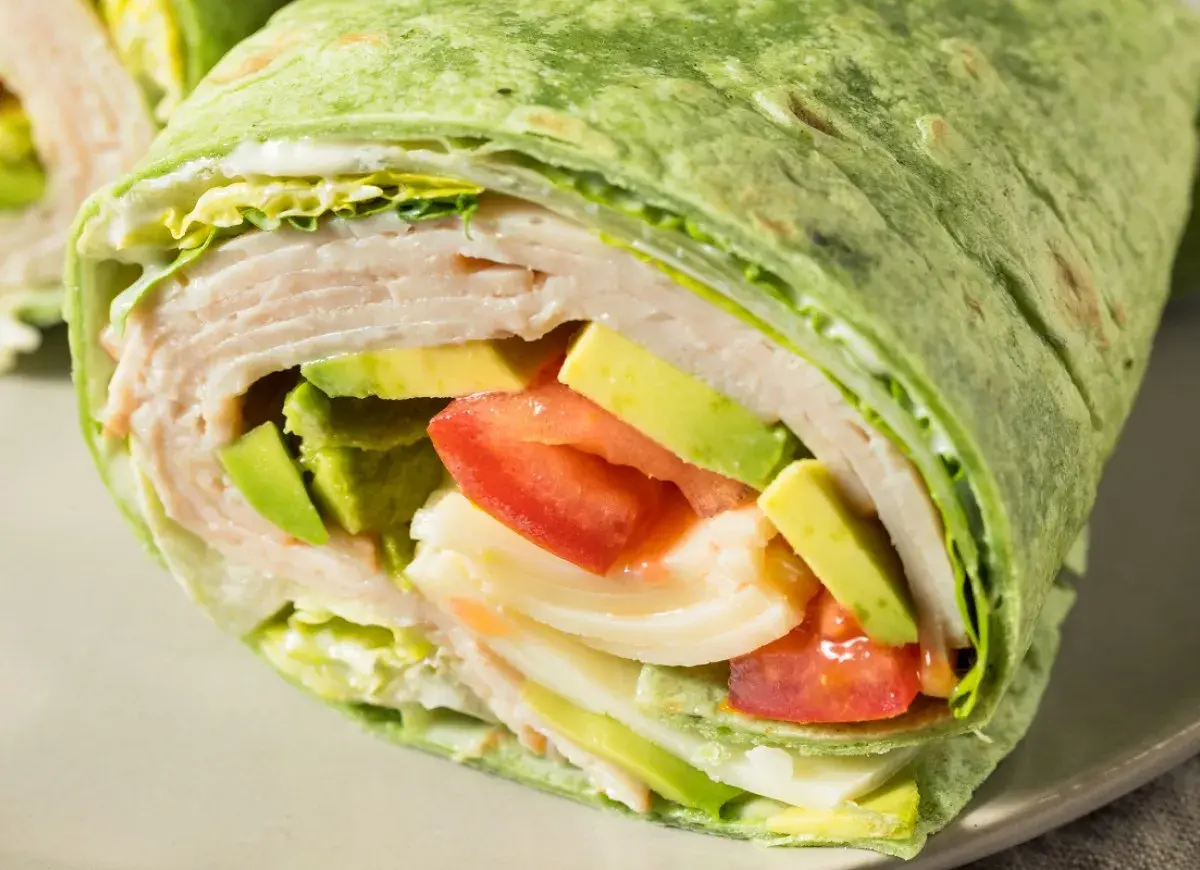 Zielona tortilla z cukinii wypełniona indykiem, awokado, pomidorem i sałatą. Pyszny i zdrowy wrap.