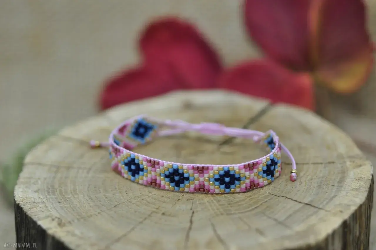 Kolorowa bransoletka z koralików diy, ozdobiona geometrycznym wzorem, spoczywa na drewnianym plastrze.