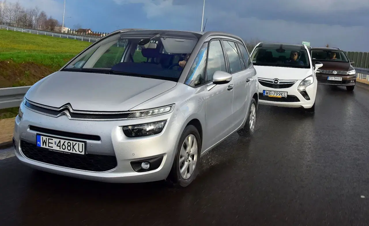 Srebrny Citroen Picasso, biały Opel Zafira i brązowy Volkswagen Touran jadą drogą. To najlepsze minivany na rodzinną podróż.