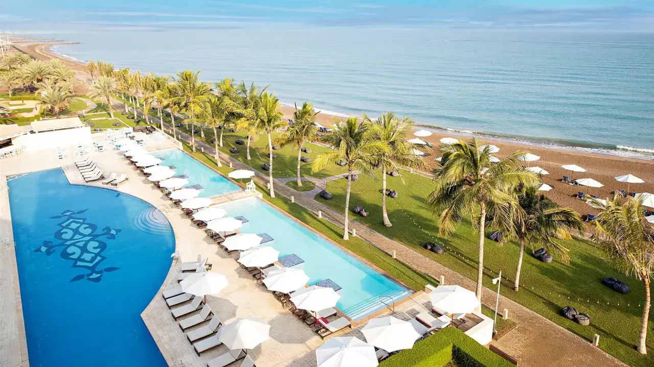 Widok na baseny i plażę z palmami przy Barcelo Hotel. Idealne miejsce na relaks.