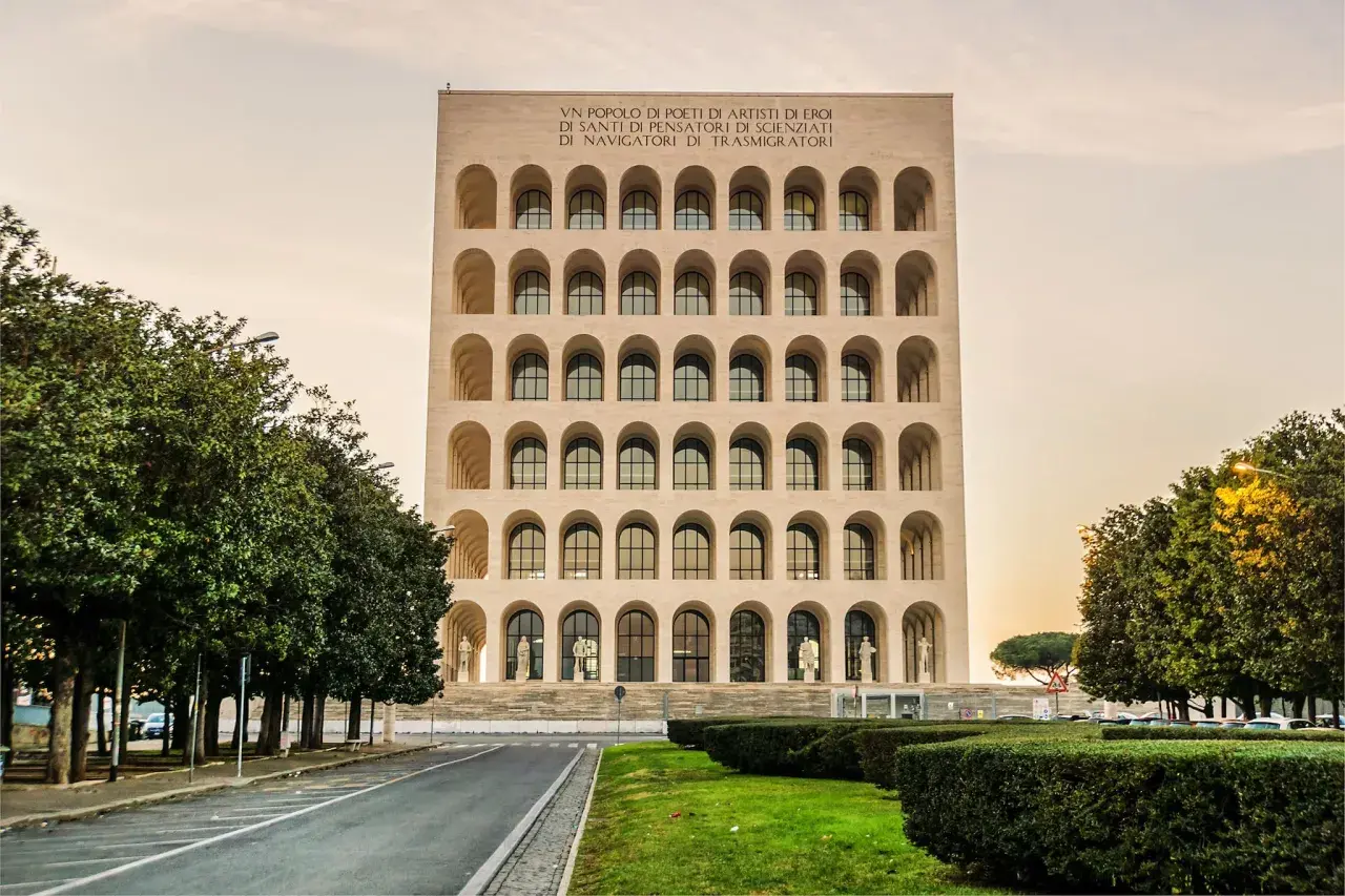 Il Palazzo della Civiltà Italiana, con le sue arcate iconiche, si erge maestoso. All'interno, le statue e le finestre creano un'atmosfera di grandezza.