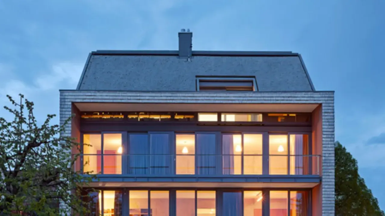Modernes Haus mit großzügigen Glasflächen und einem schlichten Satteldach, das klassische Formen neu interpretiert.