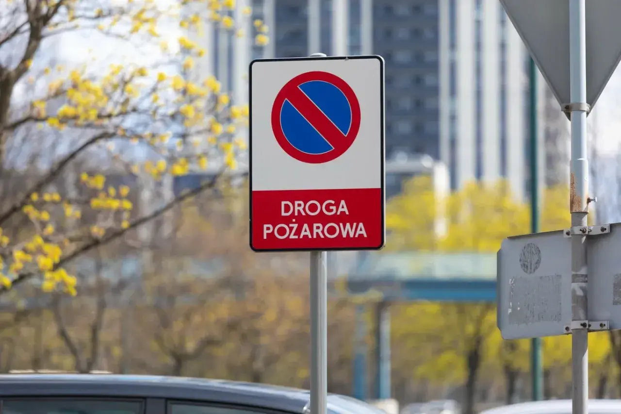 Znak zakazu zatrzymywania się na drodze pożarowej. Upewnij się, że droga jest wolna dla straży pożarnej.
