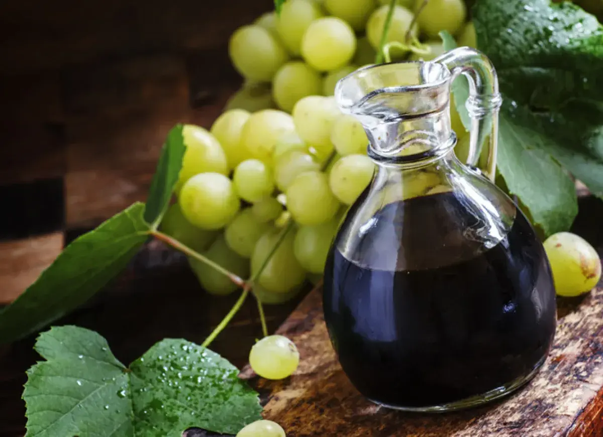 Ciemny płyn w karafce i winogrona. Szukasz, czym zastąpić ocet balsamiczny? Oto inspiracja.