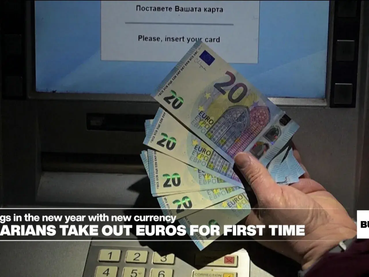 Ręka trzyma banknoty 20 euro przy bankomacie. Bułgarzy po raz pierwszy wypłacają nową walutę.