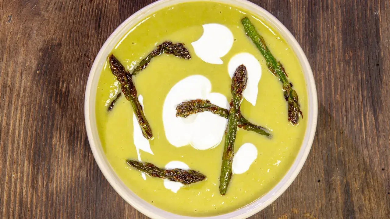 Crema di asparagi vellutata con asparagi arrostiti e un tocco di panna.