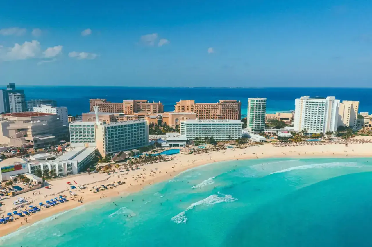 Traumhafter Strand in Mexiko, Cancun. Türkises Meer, weiße Hotels und Palmen säumen die Küste.