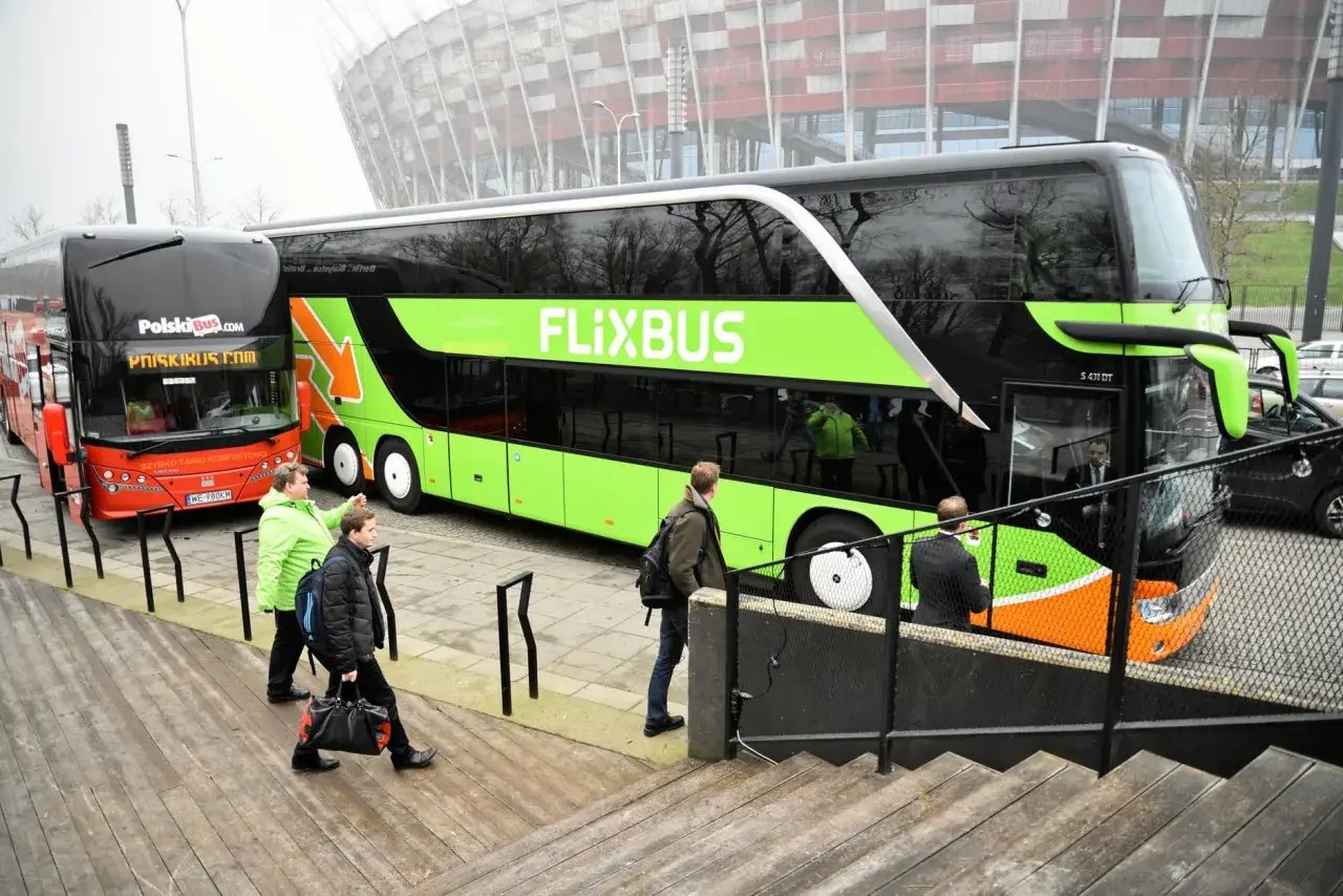 Dwa autokary Flixbus i PolskiBus stoją obok siebie.