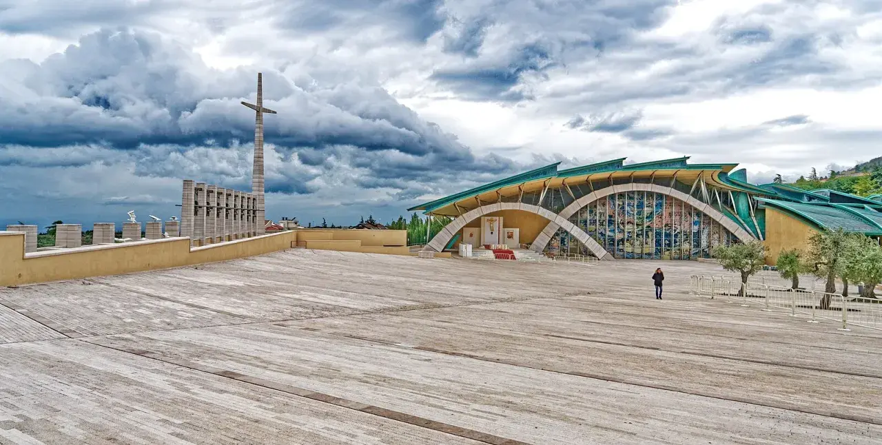 Piazza del Santuario di San Pio, il paese di Padre Pio, con la sua architettura moderna e il cielo drammatico.