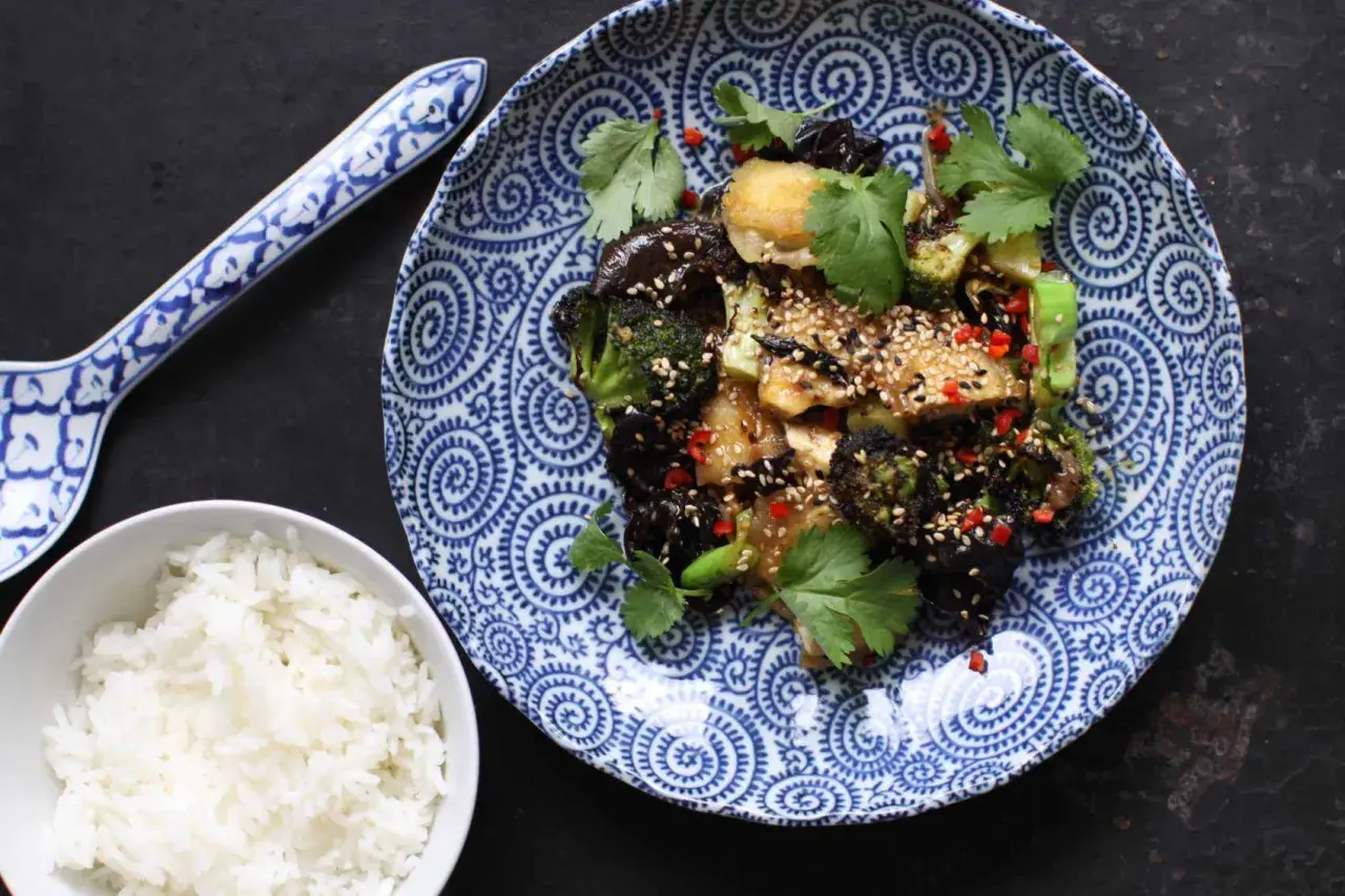 En smakrik tofu wok med broccoli, svamp och chili, toppad med sesamfrön och koriander. Serveras med ris.