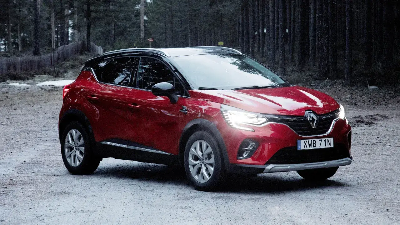 Röd Renault Captur, redo för ett begagnat test i skogen.