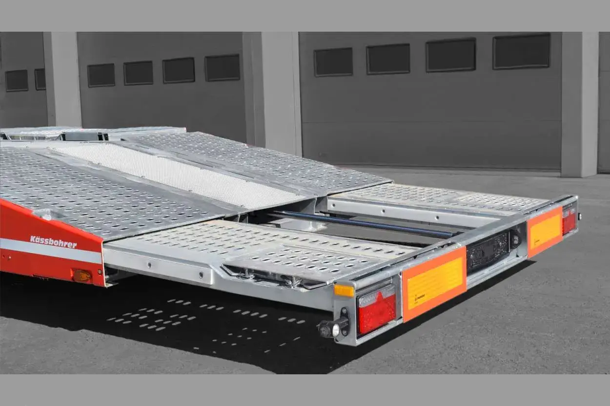 Ein roter Kässbohrer Autotransporter mit ausziehbarer Ladefläche, bereit für den Transport.