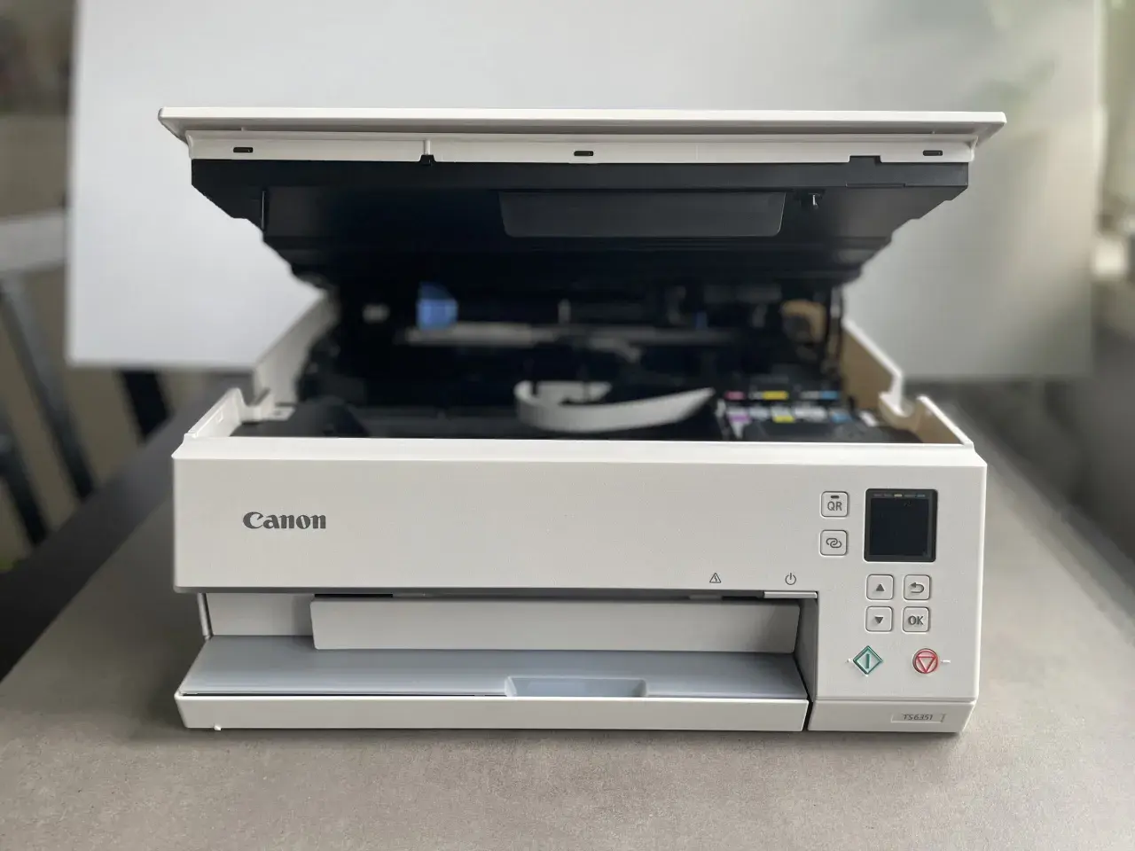 Drukarka Canon TS6351 z otwartą klapą, gotowa do drukowania. Dowiedz się, jak połączyć drukarkę Canon z telefonem, by drukować bezprzewodowo.