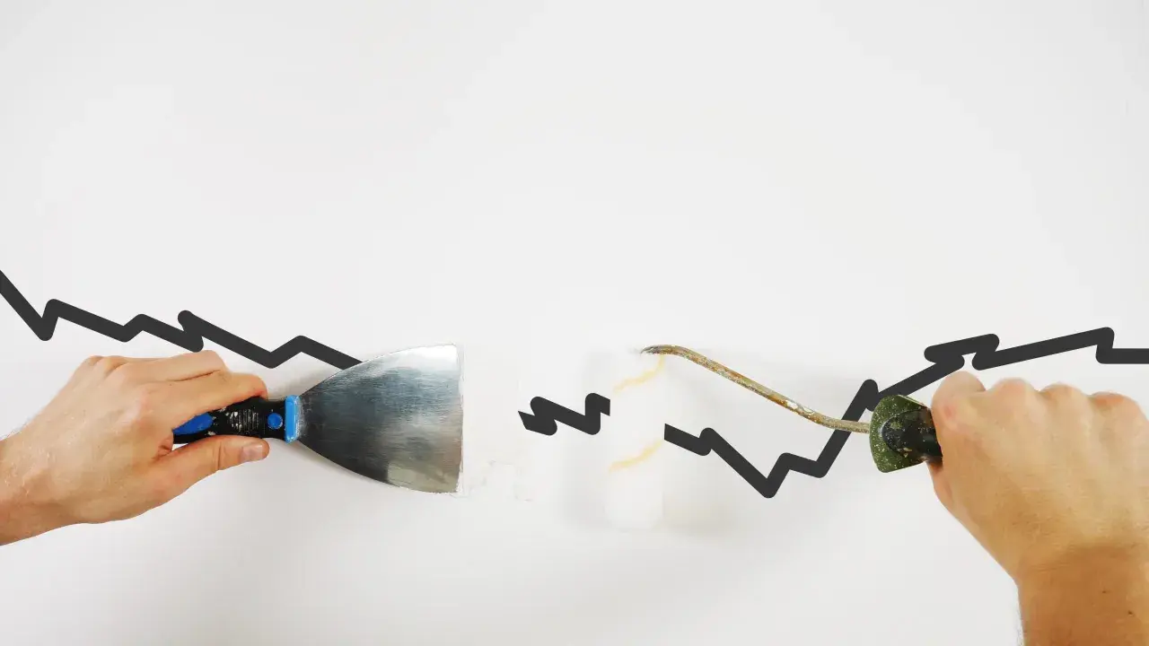 Hände reparieren mit Spachtel und Rolle eine gezackte Linie, die wie **risse in der wand** aussieht.