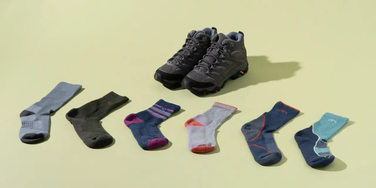 Hiking boots and six pairs of colorful socks are laid out. Is wearing two pairs of socks bad? This image shows options for comfort.