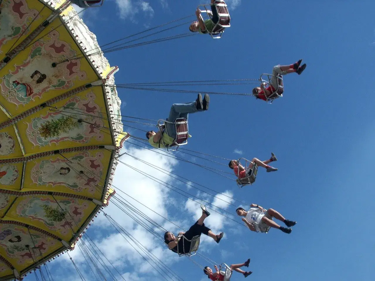 Flugkarussell auf dem Volksfest Gmund. Menschen schweben im Himmel, die bunte Kirmes dreht sich.