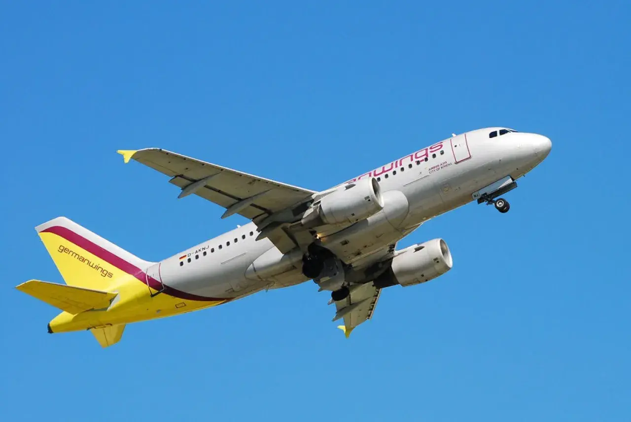 Samolot Germanwings z żółtym ogonem wznosi się na tle błękitnego nieba.