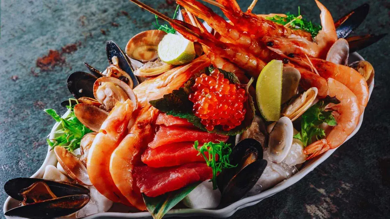 Exquisito marisco de temporada: gambas, mejillones, almejas y atún fresco, coronado con huevas de salmón y rodajas de lima.