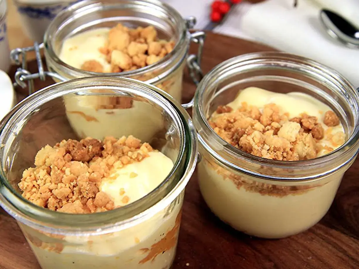 Tre små glasburkar med len vit chokladmousse toppad med smulig crumble. Perfekt för en fika!