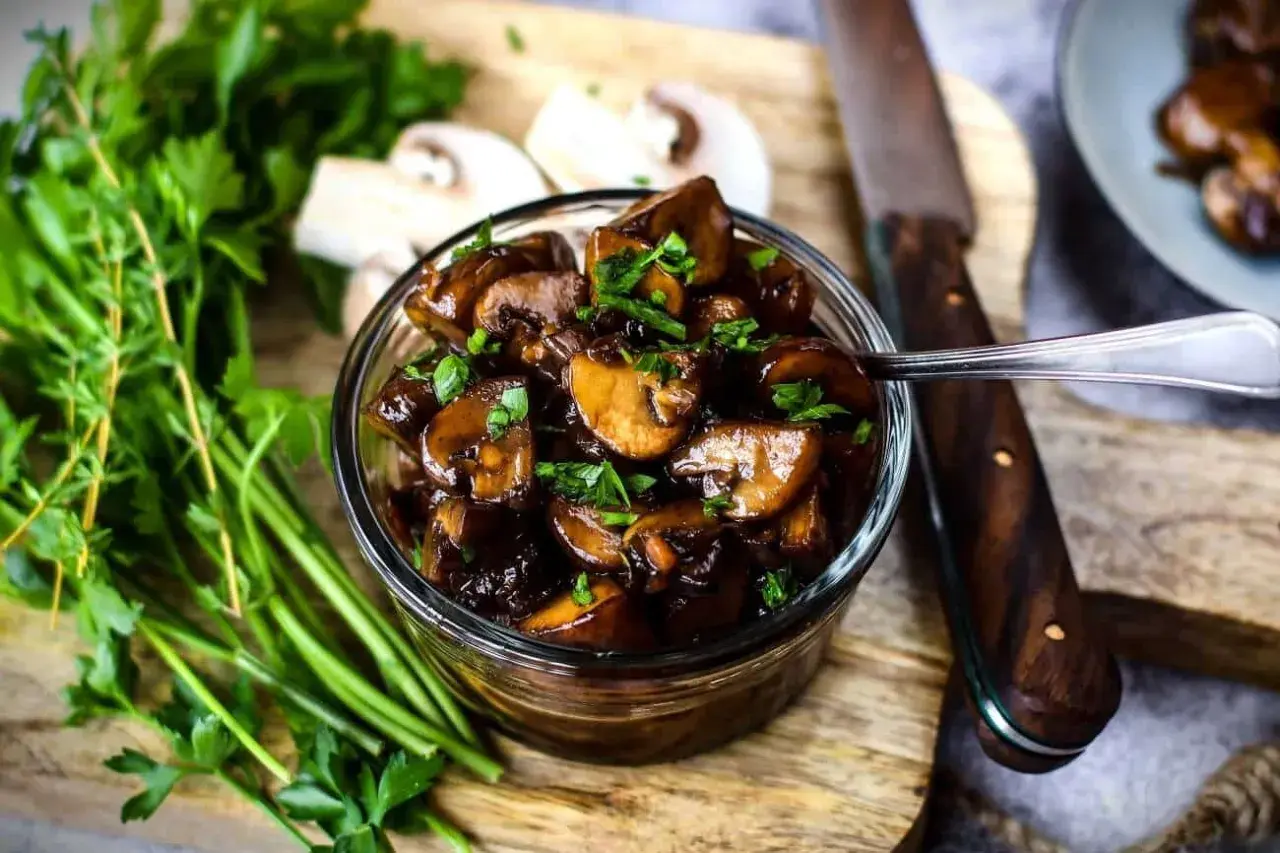 Schmackhafte Champignons in dunkler Sauce, garniert mit Petersilie. Perfekt für Ihre nächsten Champignons Rezepte.