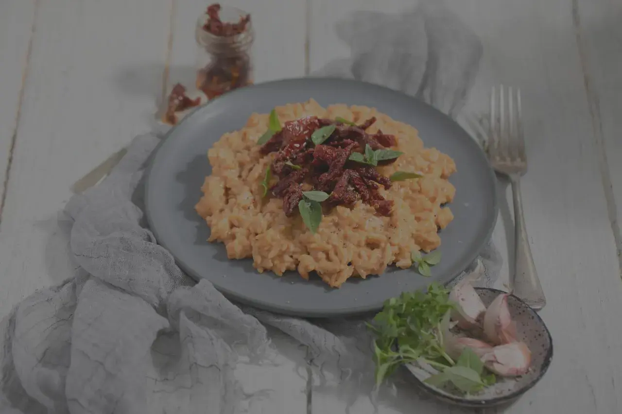 Cremiges Risotto mit getrockneten Tomaten und Basilikum. Man kann Risotto einfrieren, aber die Konsistenz verändert sich.