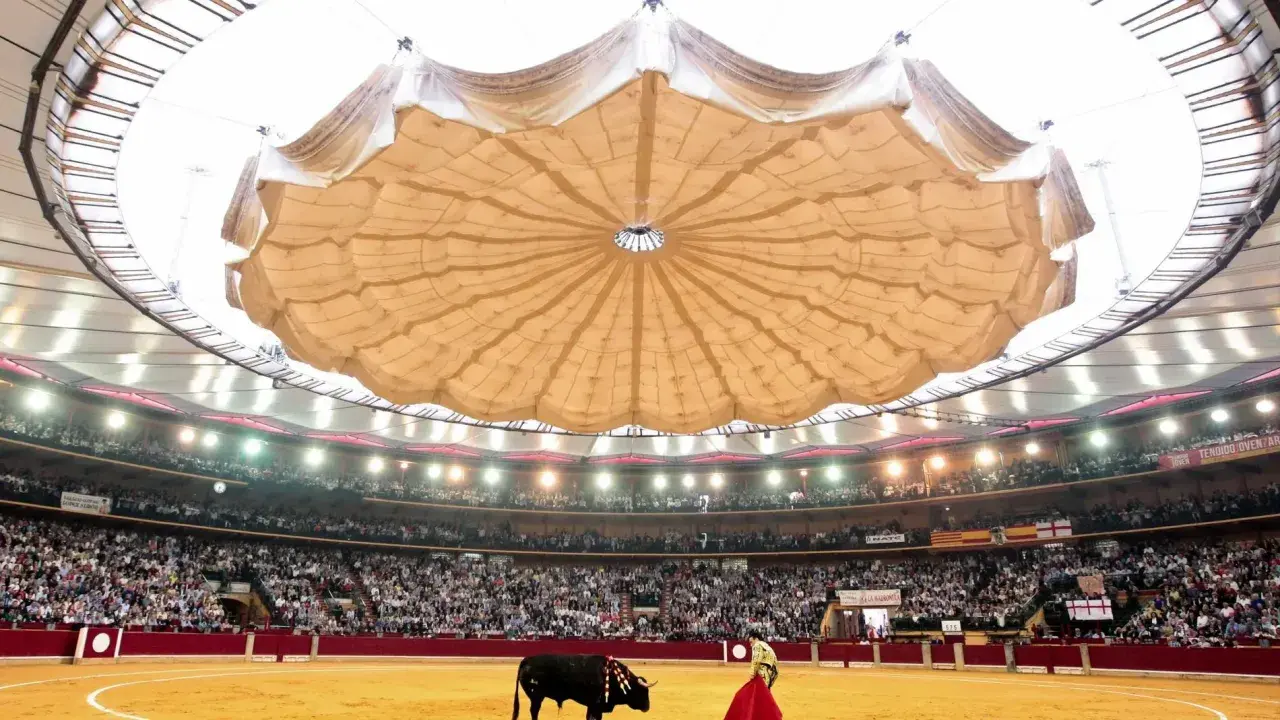 Vista del ruedo y los asientos de la plaza de toros de Zaragoza, con un toro y un torero en la arena, bajo una gran cubierta.