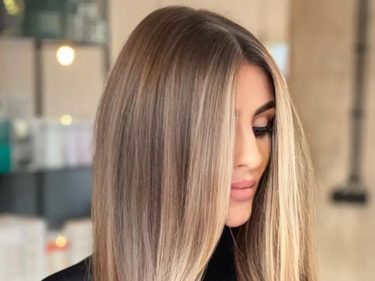 Kobieta z pięknymi, długimi, **front blond** włosami, delikatnie opadającymi na twarz.