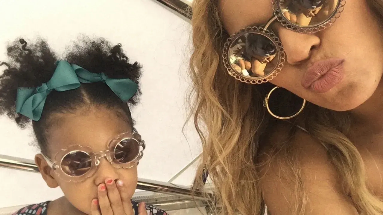 Mała córka Beyoncé w okularach w kształcie kwiatków i zielonej kokardce, obok mamy w okularach z ozdobnymi oprawkami.