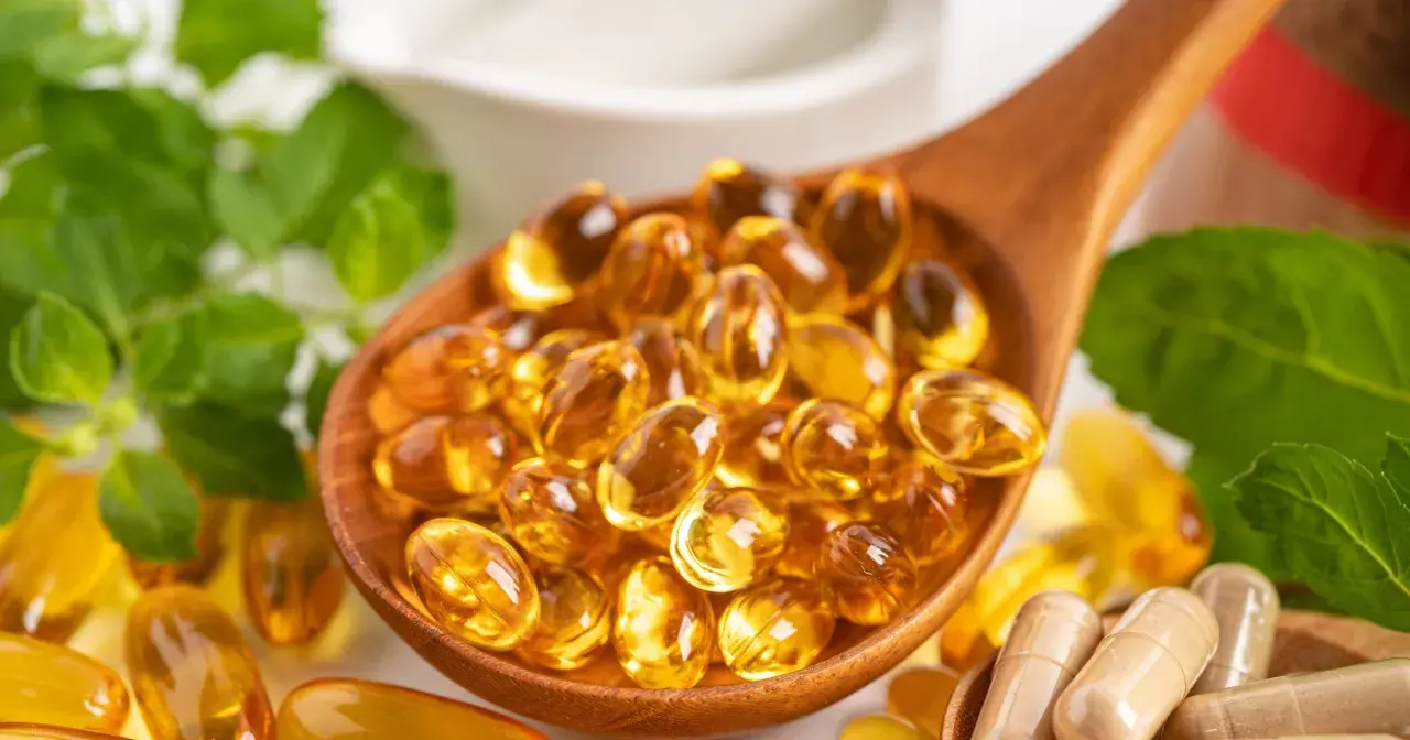 Łyżka pełna kapsułek z omega 3. Kwasy te wspierają serce, mózg i wzrok.