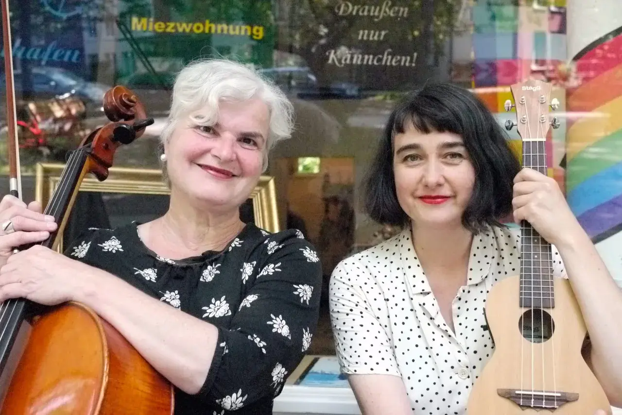 Zwei Musikerinnen mit Cello und Ukulele, bereit für das Hörbuch "das kunstseidene Mädchen".