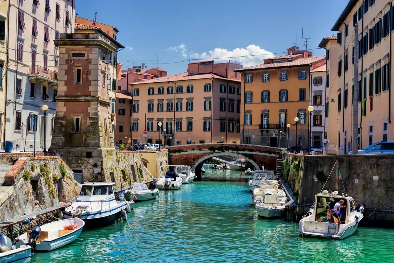 Canaux de Livourne, bateaux amarrés, bâtiments colorés et un pont. Idéal pour savoir que faire à Livourne.