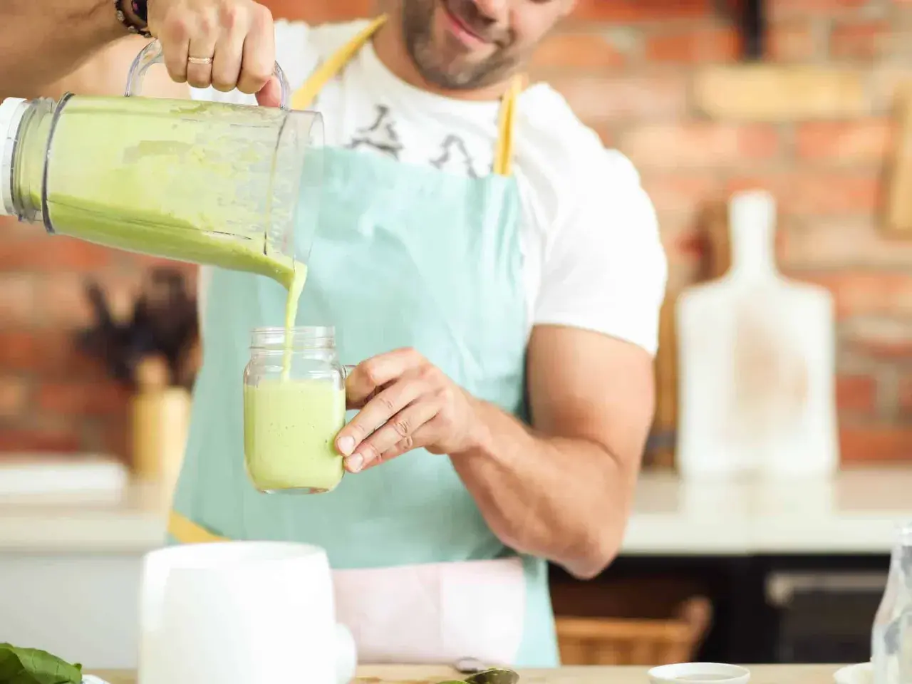Hombre vertiendo un batido verde cremoso, ideal para quienes buscan alternativas a los tipos de leches vegetales.