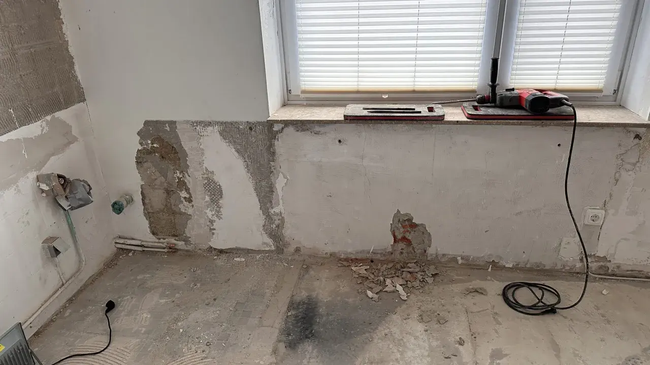 Baustelle mit Werkzeug und freiliegendem Mauerwerk, das auf eine bevorstehende Verkieselung hindeutet.