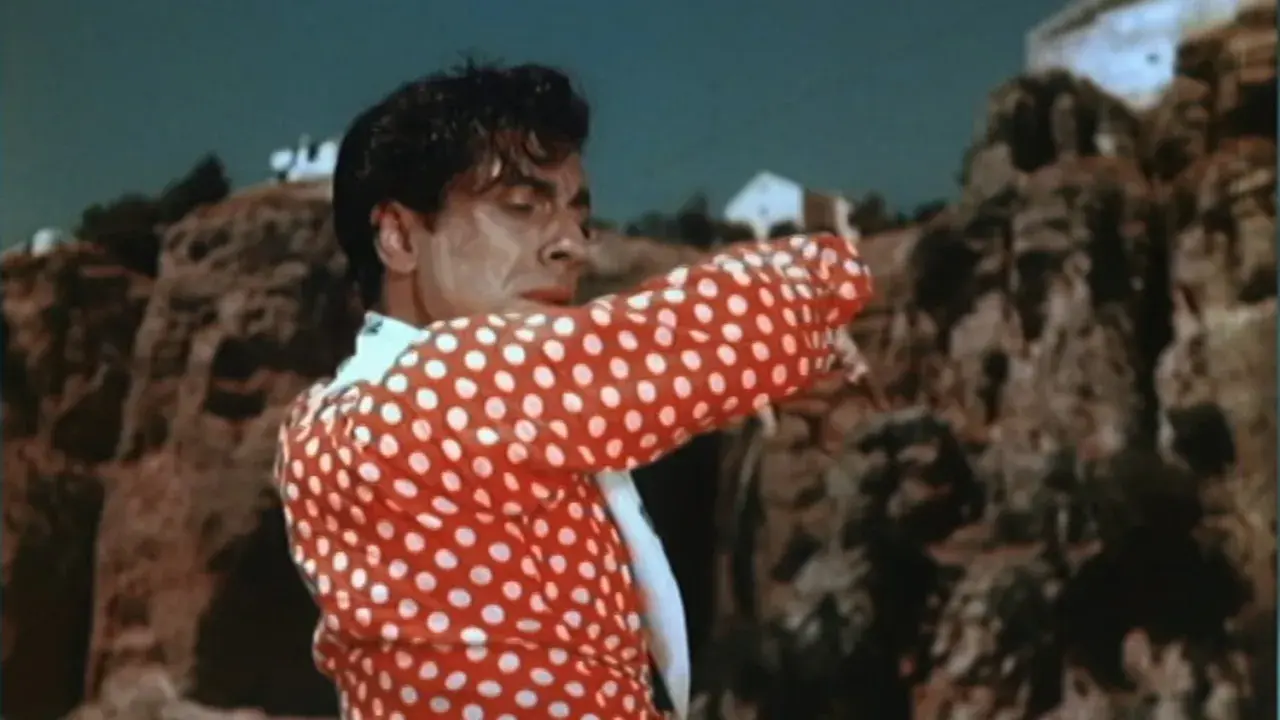 Un hombre con camisa de lunares rojos y blancos, bailando con pasión. Su gesto evoca la fuerza de la contrahecha.