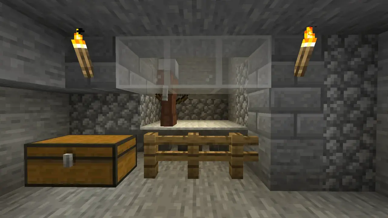 W klatce z Minecrafta stoi villager, gotowy na komendę na zabicie mobów. Obok skrzynia i pochodnie.