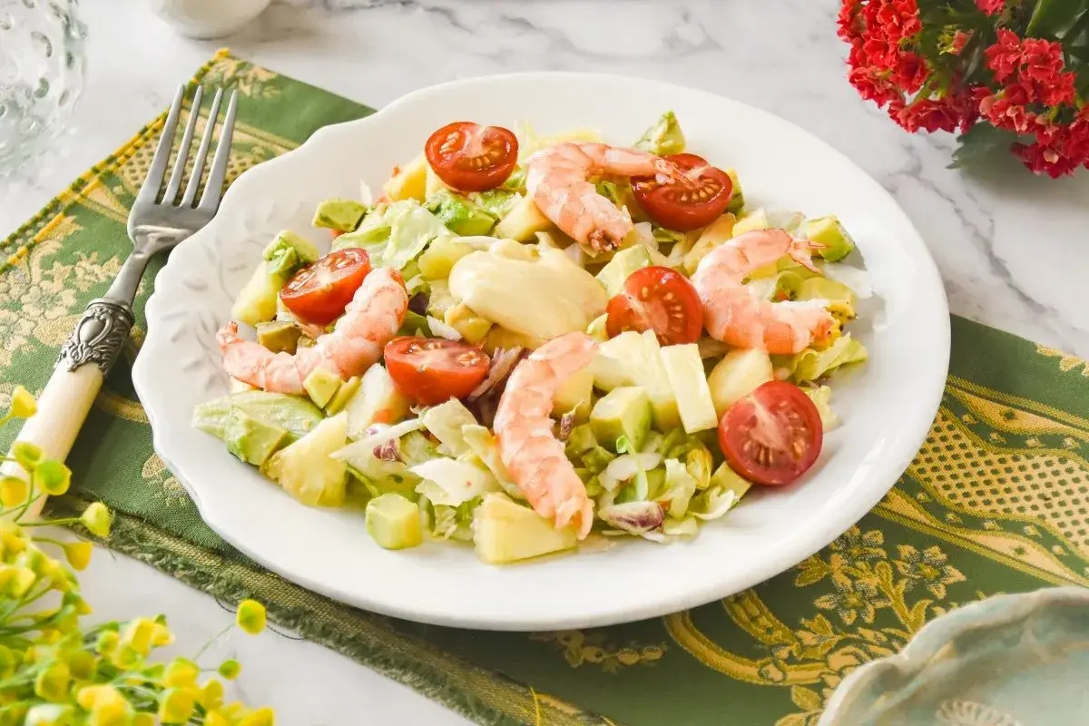 Ensalada tropical con camarones, aguacate, piña y tomates cherry. Un festín de sabores frescos y vibrantes.
