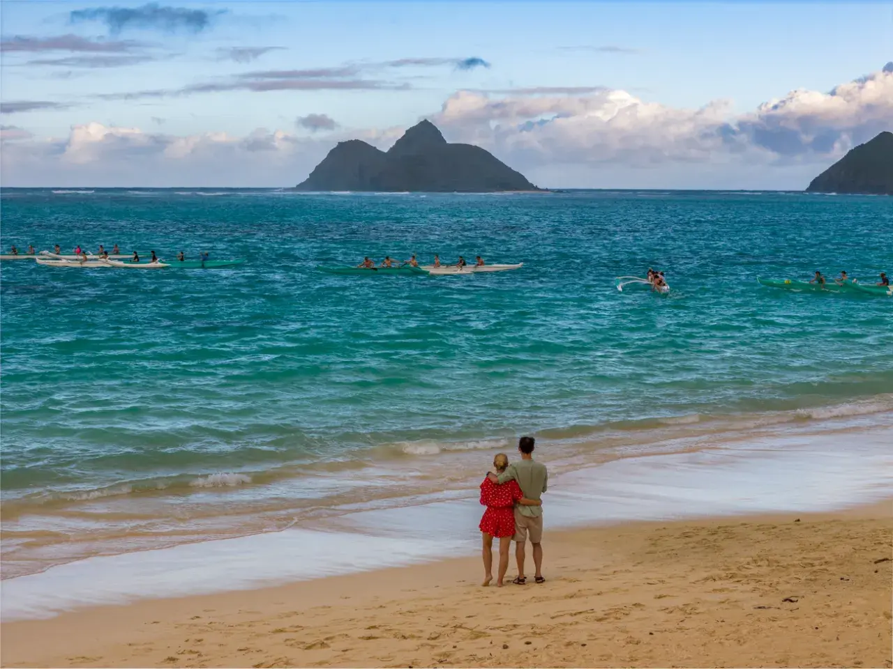 Para młoda na plaży, podziwiająca ocean i łodzie. Idealne miejsce na podróż poślubną.