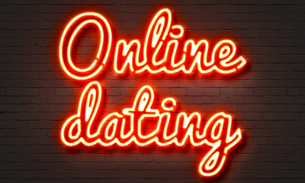 Neonowy napis "Online dating" na ceglanej ścianie. Szukasz odpowiedzi, gdzie poznać dziewczynę w sieci?