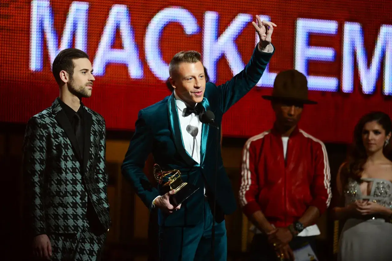 Macklemore odbiera nagrodę Grammy: najlepszy debiutujący artysta. Obok niego stoją Lewis Hamilton, Pharrell Williams i Anna Kendrick.