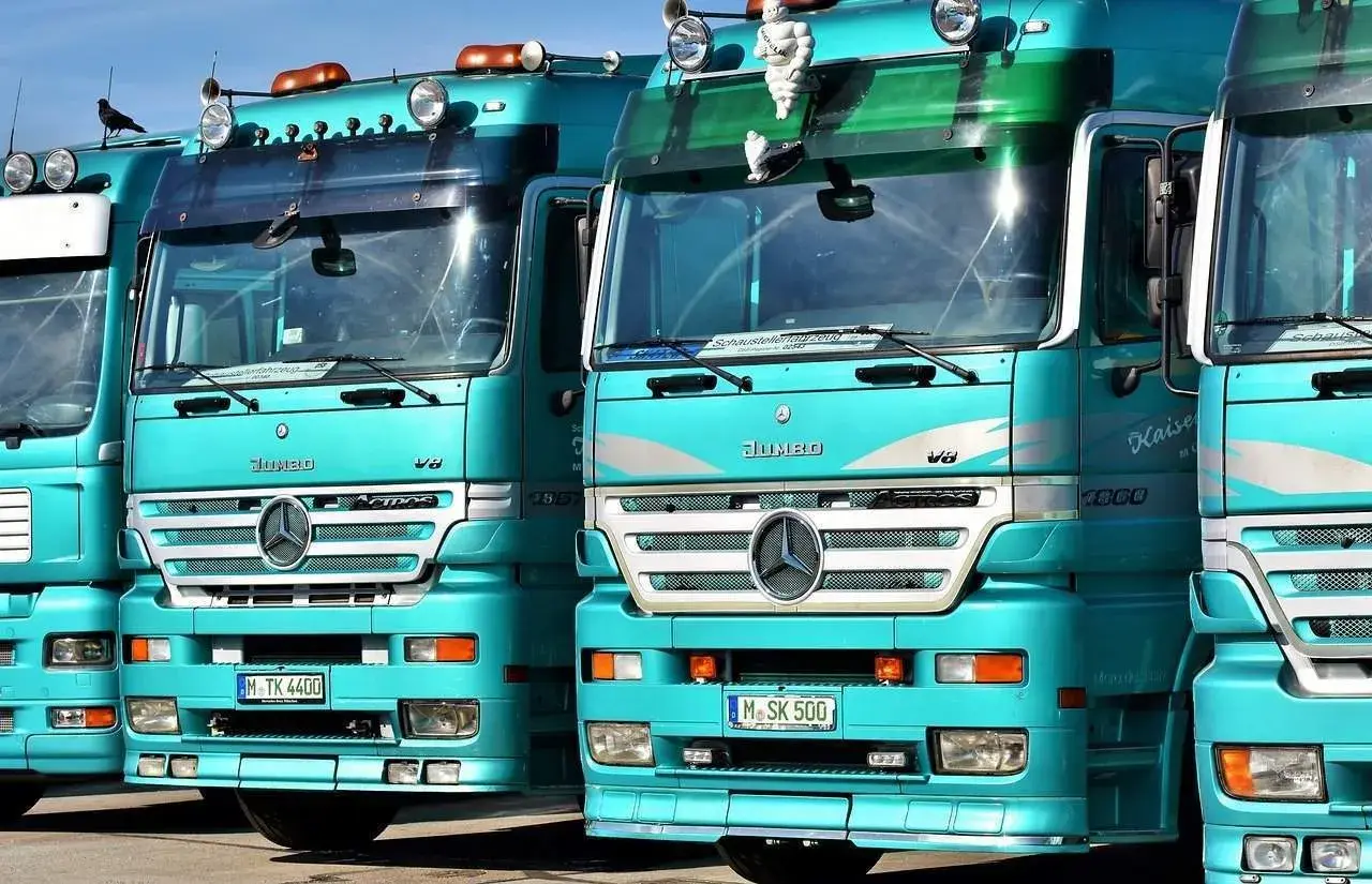 Varios camiones Mercedes-Benz Actros turquesas en fila. ¿Cuántos litros de aceite lleva un camión? Depende del modelo, pero estos gigantes pueden necesitar entre 20 y 40 litros.