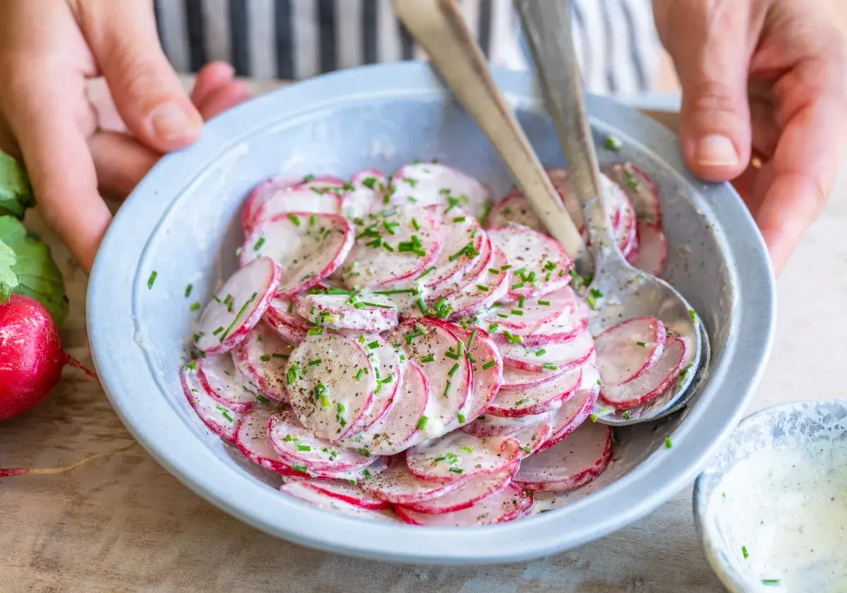 Frischer Radieschen Salat mit Schnittlauch und einer cremigen Soße, bereit zum Servieren.