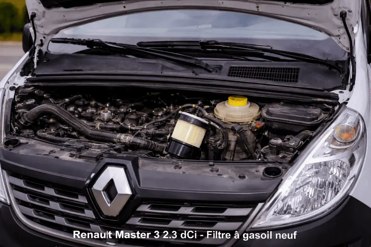 Moteur de Renault Master 3 2.3 dCi ouvert, montrant le **changement filtre à gasoil** en cours. Le nouveau filtre est visible.
