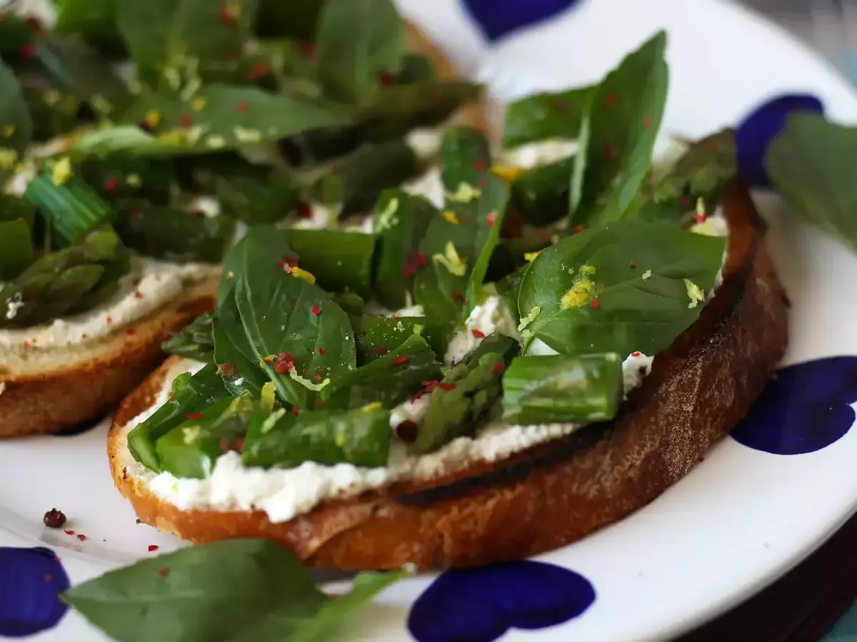Krispigt rostat bröd med krämig ost, sparris och basilika. Ett perfekt bruschetta recept för en lätt lunch eller förrätt.