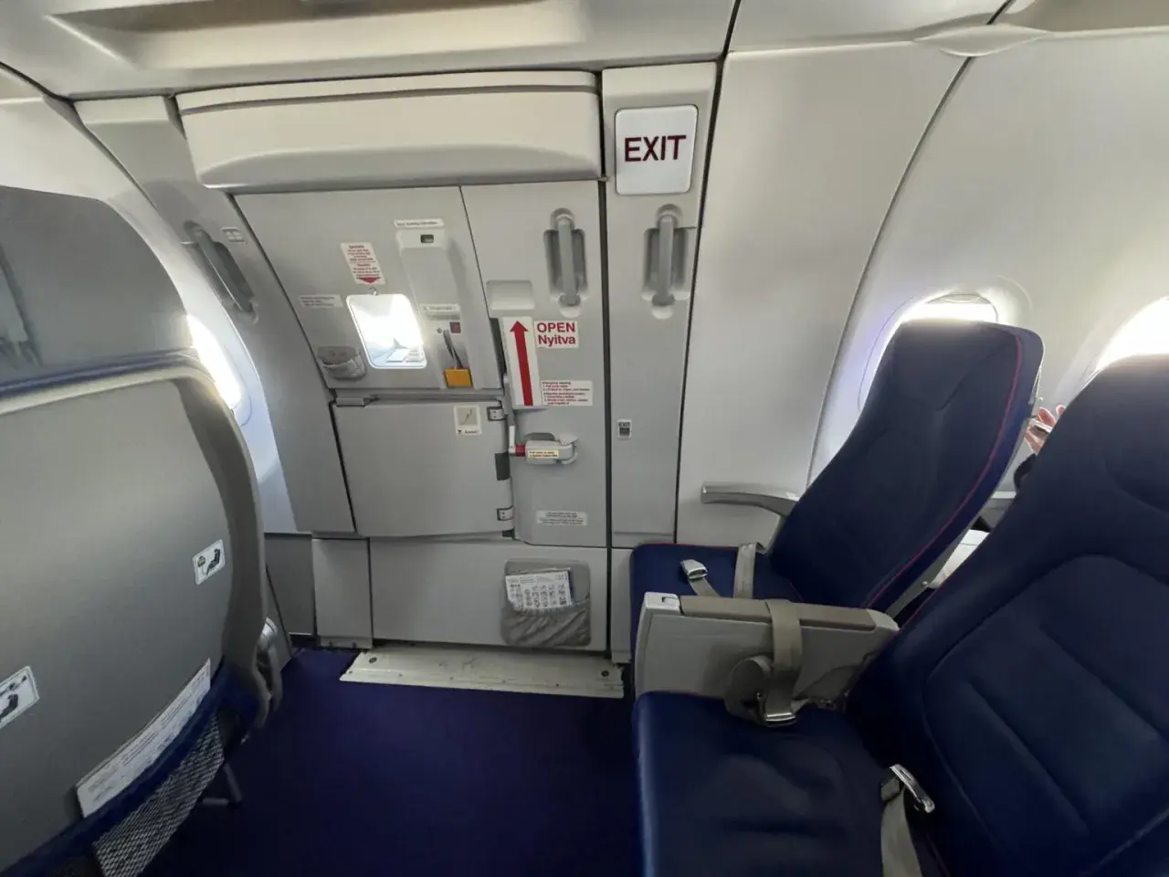 Wizz rozkład miejsc w samolocie Wizzair. Widok na rząd siedzeń i drzwi wyjściowe.